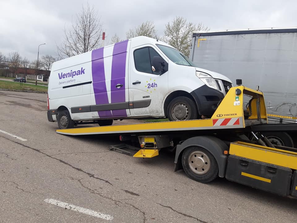 Mikroautobusas pakrautas kroviniais ant platforminio tralo